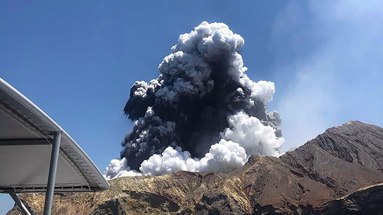 A plume of ash rising into the air as the volcano on White Island erupts.