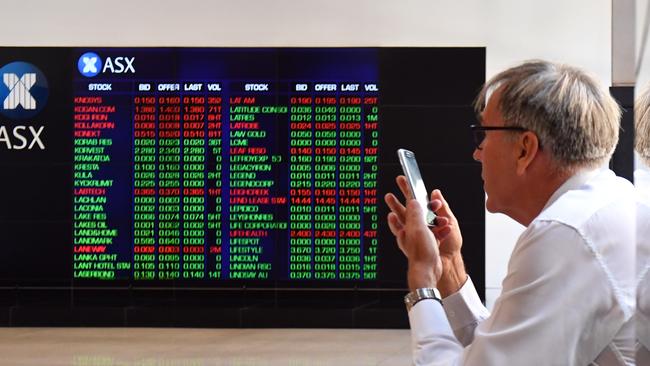 An investor looking at the ASX trading board in Sydney. Picture: AAP Image/Mick Tsikas