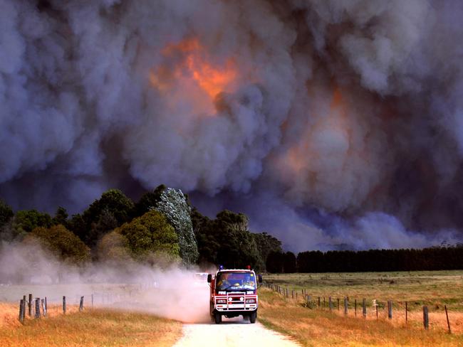 Photograph taken by photographer Alex Coppel of a CFA fire truck leaving area as smoke from a giant blaze so big it resembles a nuclear explosion, burning close to Labertouche near Pakenham in Bunyip State Forest, east of Melbourne during Victorian Black Saturday Bushfires on 07/02/2009. Pic Alex CoppelSTRICT CONDITIONS: There are 50 pictures in this assignment which are for use in The Australian's 50th anniversary magazine. They can not be used elsewhere until after the 15th July 2014. No use is permitted without contacting the Picture Editor of The Australian. HS25