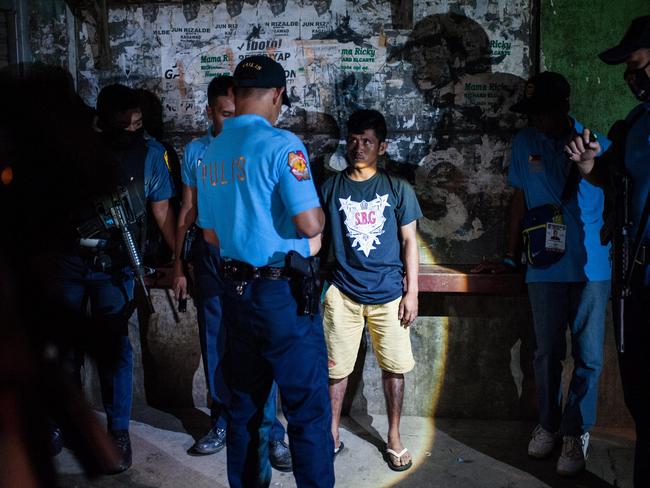 Police question a man during a night patrol at a shanty community in Manila, last week. Picture: Dondi Tawatao/Getty Images
