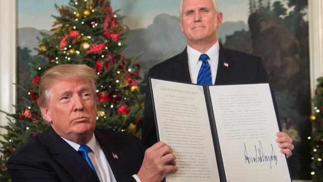 Donald Trump holds up a signed memorandum after he delivered a statement on Jerusalem. Picture: Saul Loeb