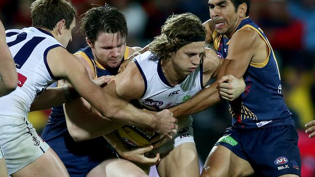 Nat Fyfe is tackled by Patrick Dangerfield and Eddie Betts. Picture: Simon Cross