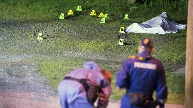 Forensic police investigate the body found in the carpark. Picture: Andy Brownbill