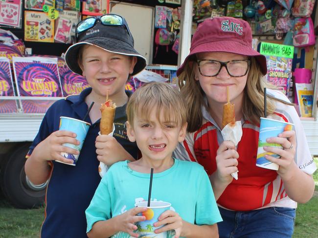 HAPPY DAYS: Karmicheal Armstrong, Jayden Mcaleese and Kelliegh Armstrong tucking into some food at the Murgon Show at the Murgon Show. Photo: Laura Blackmore