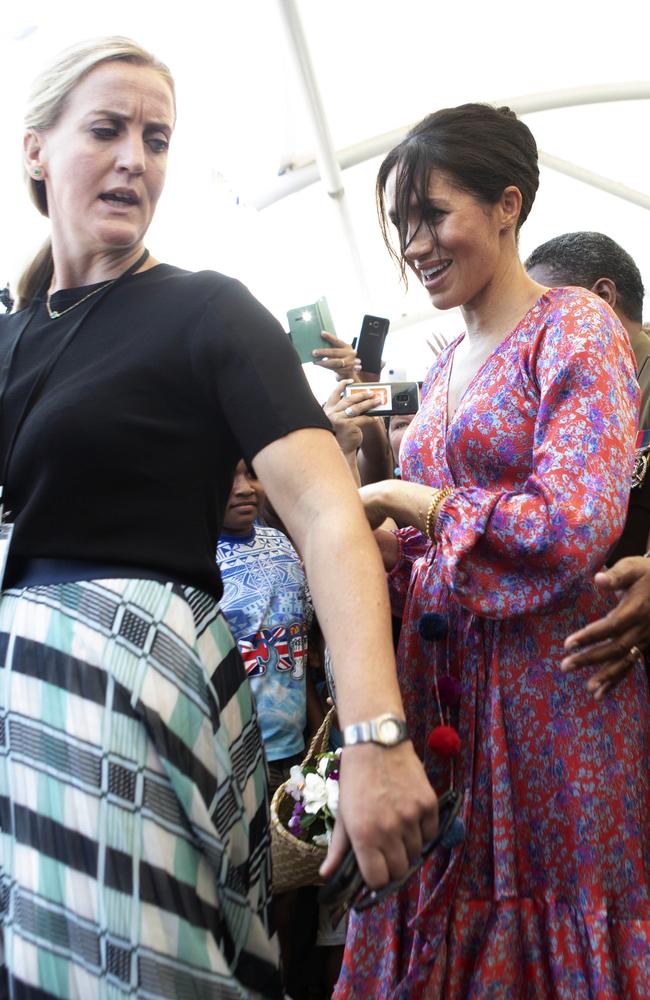 Meghan, Duchess of Sussex, is rushed through a market in Fiji. Picture: AP
