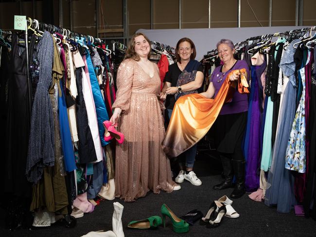 Sam Oakes (centre) with volunteers Adeline Veech and Julie Murphy in 2023. In their first year at Minto Mall, The Formal Project clothed 1300 kids. This year, they helped more than 9500. Picture: Brendan Read