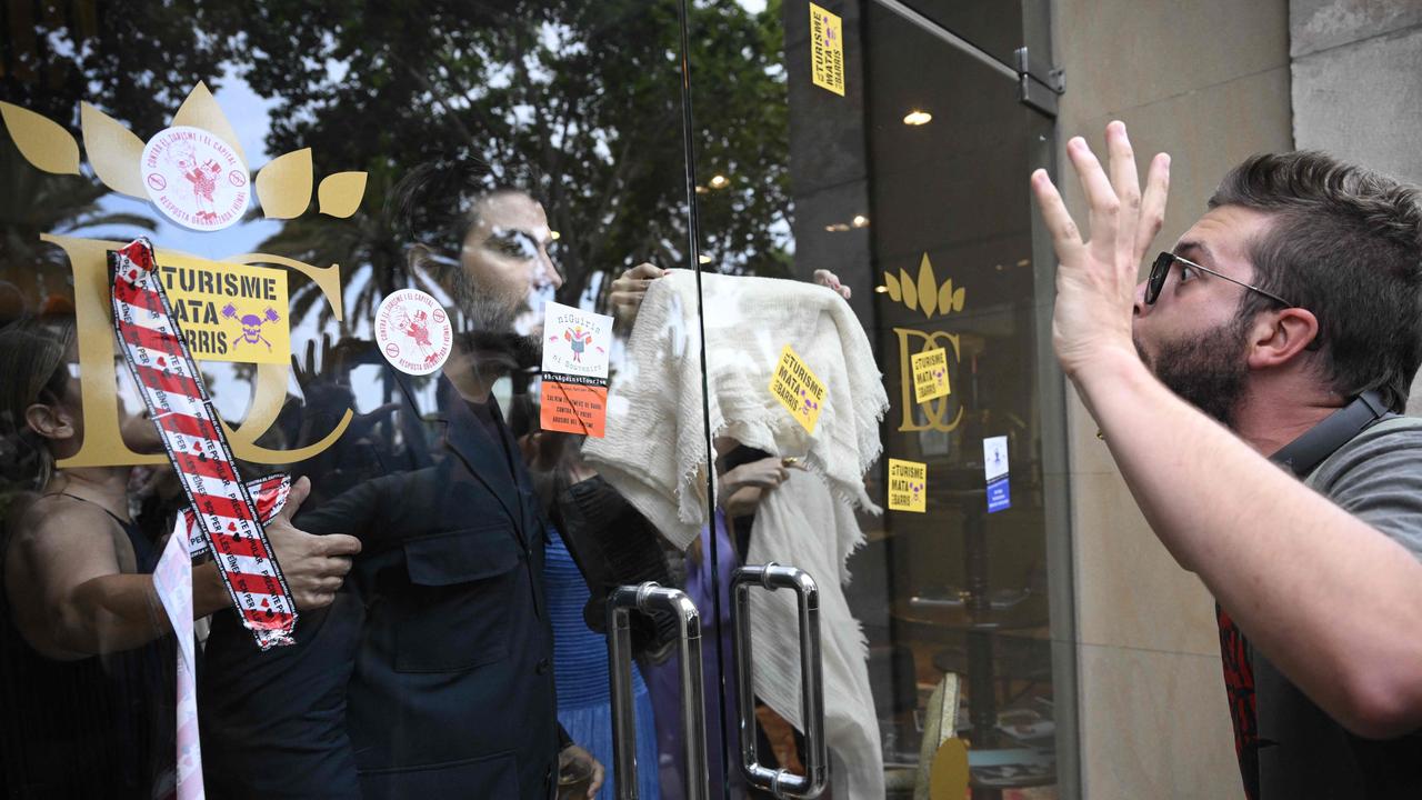 Demonstrators protest in front of a bar-restaurant. Picture: Josep LAGO/AFP