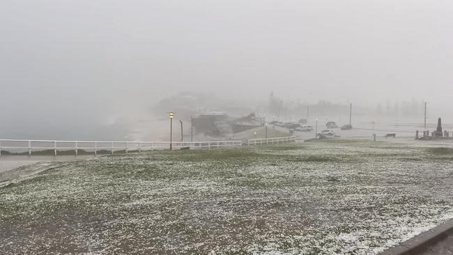 Hailstones create a white blanket across Bar Beach. Photo: David Diehm