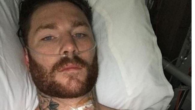 Chris McQueen in hospital after neck surgery.