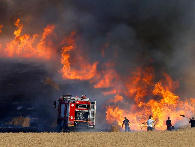 Israeli firemen attempt to put out a fire in a wheat field near the Kibbutz of Nahal Oz along the border with the Gaza Strip. Picture: AFP/Jack Guez