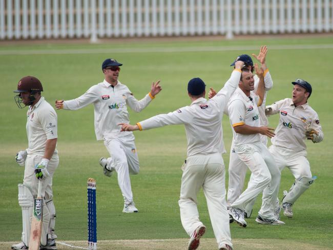 Veteran West Torrens paceman Trent Kelly is mobbed by teammates after dismissing Kensington skipper Jake Brown. Picture: Simon Stansbury.