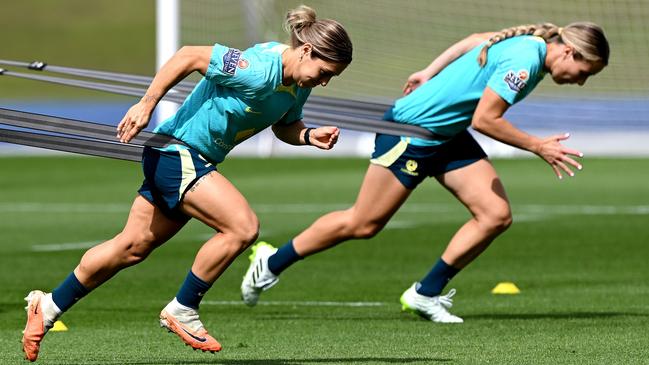 Katrina Gorry, left, leads her teammate through their paces during a Matildas training session at the Queensland Sport and Athletics Centre in Brisbane on Friday. Picture: Bradley Kanaris/Getty Images