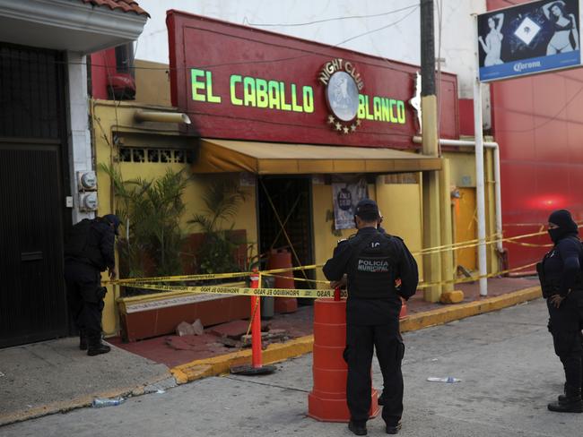 Police officers guard the scene outside a bar where more than 20 people died in an overnight attack, in Coatzacoalcos, Mexico. Picture: AP