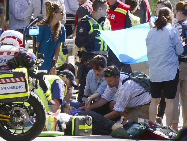 Paramedics treat victims at the scene. Picture: Cameron Tandy