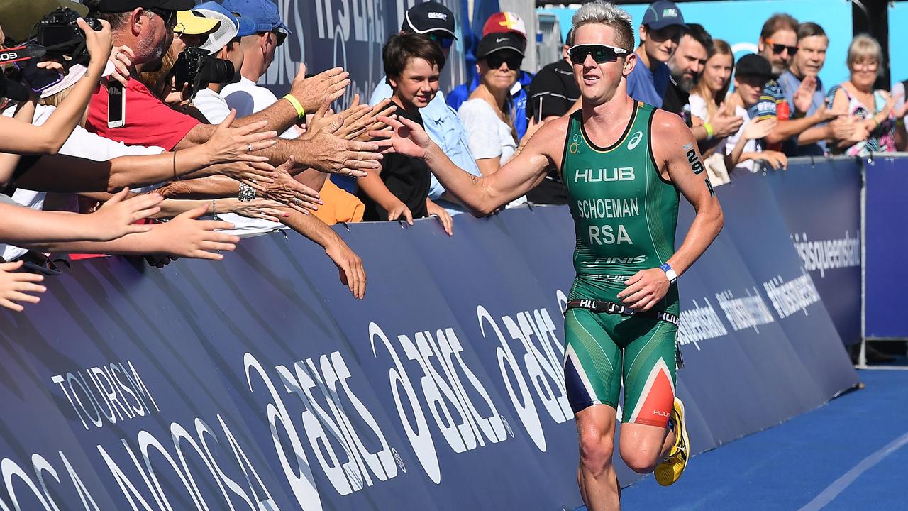 Back in the day before COVID-19, a competitor crossing the Noosa Triathlon finish line in front of big crowd.