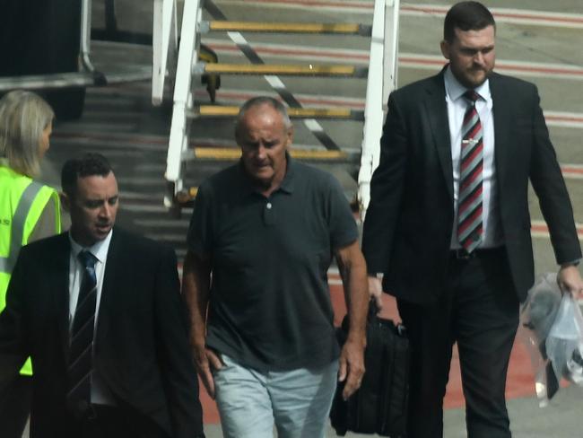 Chris Dawson (centre) being escorted by NSW Police detectives after his extradition from Queensland. He was charged and found guilty of his wife’s murder. Picture: AAP Image/Dean Lewins