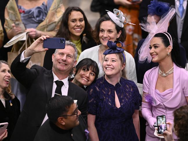 Katy Perry, in lavender outfit, poses for selfies with Adam Hills and guests during the coronation. Picture: Getty Images