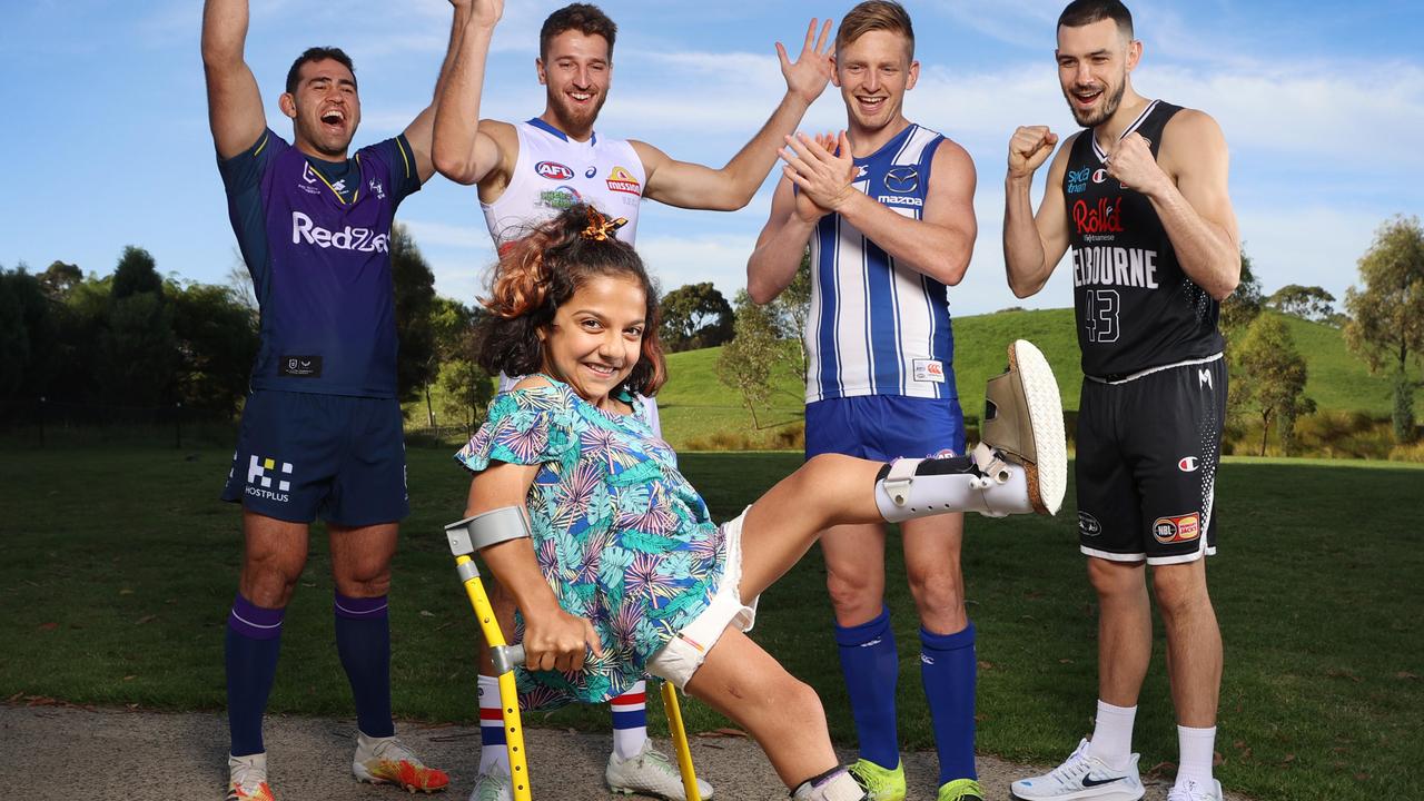 Hasti Momeni gets her kicks with Western Bulldogs skipper Marcus Bontempelli, North Melbourne captain Jack Ziebell, Melbourne Storm co-captain Dale Finucane and Melbourne United captain Chris Goulding. Picture: Michael Klein