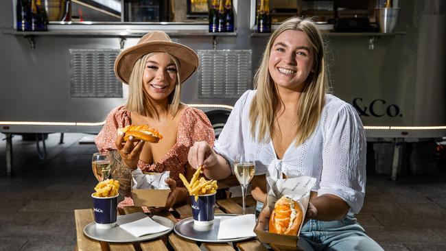 Harmony Allen, from Tasmania and Lucy Howard, from Seaton, sampling the $50 Lobster rolls. Picture: Tom Huntley