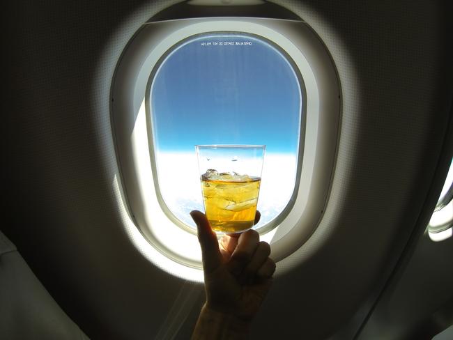 Wine bottle next to airplane window in first class flight