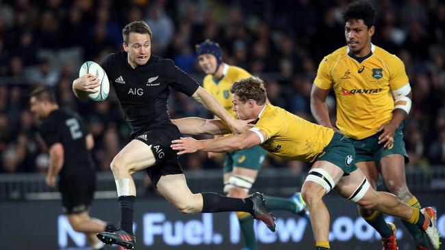 New Zealand’s Ben Smith breaks a tackle from Australia’s Michael Hooper.