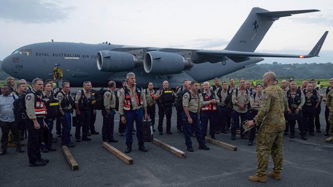 Australian emergency crews receive a briefing after landing at Bauerfield International Airport in Port Vila. Picture: DFAT / AFP