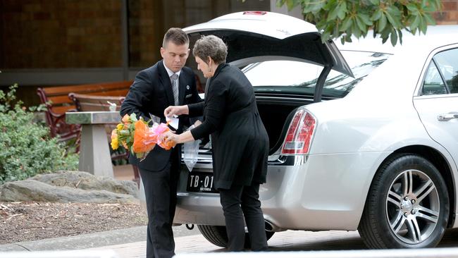 A lone bunch of flowers goes in a car at Longley’s funeral.