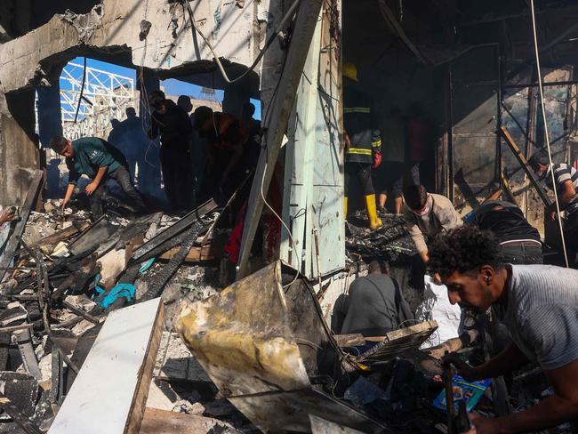 Palestinians check the destroyed Maghazi Camp Services Club building following an Israeli strike on the Maghazi refugee camp in the Gaza Strip on October 24, 2024, amid the ongoing war between Israel and Hamas.  (Photo by Eyad BABA / AFP)