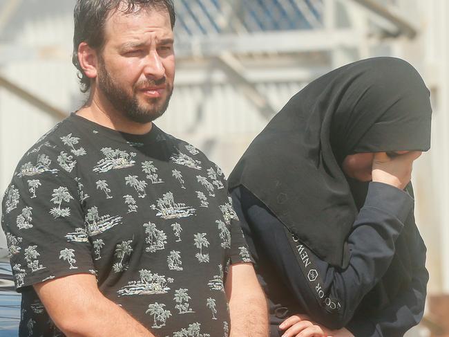 Family and co-workers look on as the body of murder victim Hassan Baydoun is removed from a unit at the Palms Motel. Picture: Glenn Campbell