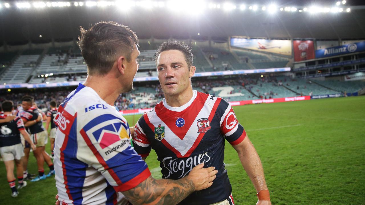 Cooper Cronk and Mitchell Pearce come together after the Newcastle star’s ugly homecoming. Picture: Brett Costello