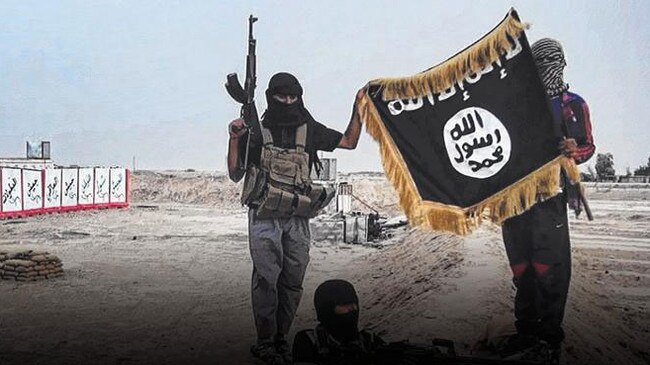 Militants of Islamic State posing with the trademark jihadists flag.