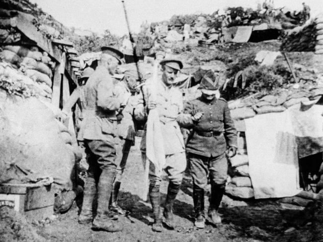 Peace, briefly ... a Turkish envoy is escorted through Australian lines to arrange a truce for burying the dead.