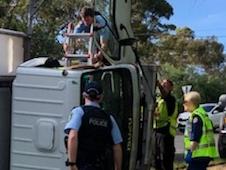 Emergency services personnel work to free the driver of a pantech truck that rolled at a roundabout at Cromer about 7.45am on Thursday. Picture: Supplied