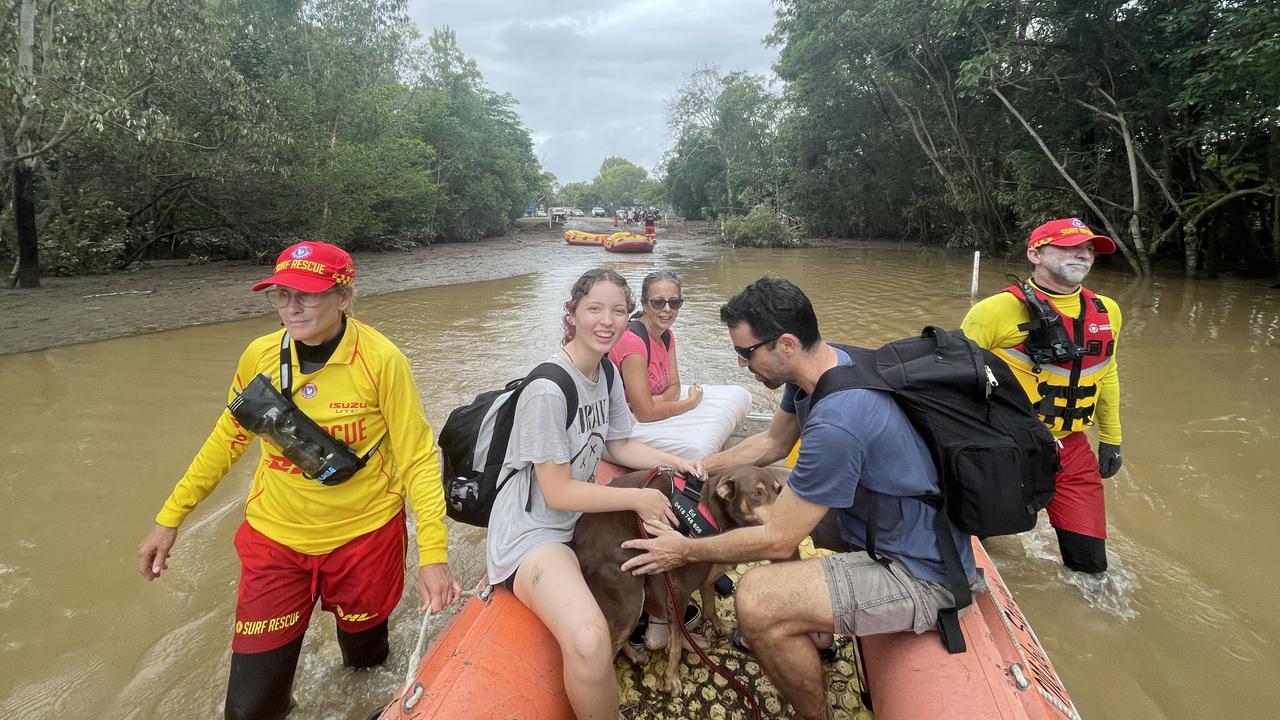 Damon and Rachel Thompson with Sharron Cupitt and Ed the dog on a rescue boat leaving Holloways Beach. Picture: Peter Carruthers