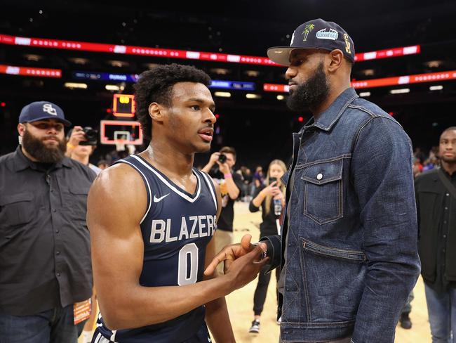 (FILES) Bronny James, #0 of the Sierra Canyon Trailblazers, is greeted by his father and NBA player LeBron James after defeating the the Perry Pumas in the Hoophall West tournament at Footprint Center in Phoenix, Arizona, on December 11, 2021. NBA superstar LeBron James said on July 27, 2023, his family was "together, safe and healthy" four days after his eldest son suffered cardiac arrest during practice with his college basketball team. (Photo by Christian Petersen / GETTY IMAGES NORTH AMERICA / AFP)