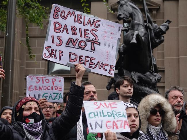 People held up signs at the rally. Picture: NCA NewsWire / Valeriu Campan