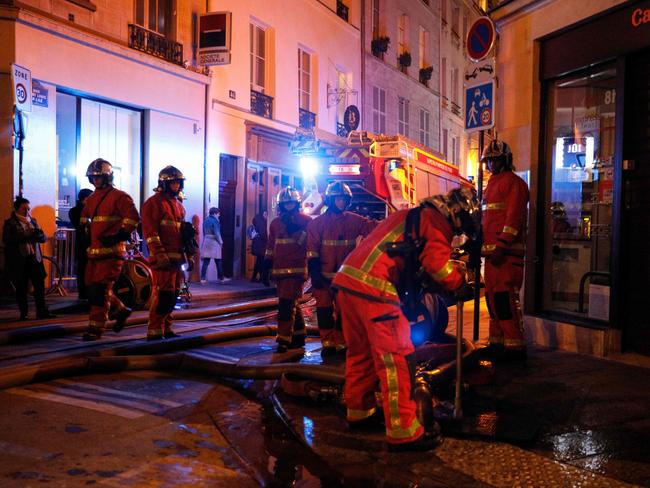 French fire fighters open water supply points as others douse a fire that engulfed the roof of the Notre-Dame de Paris Cathedral on April 15, 2019 in Paris. - A colossal fire swept through the famed Notre-Dame Cathedral in central Paris on April 15, 2019, causing a spire to collapse and raising fears over the future of the nearly millenium old building and its precious artworks. The fire, which began in the early evening, sent flames and huge clouds of grey smoke billowing into the Paris sky as stunned Parisians and tourists watched on in sheer horror. (Photo by GEOFFROY VAN DER HASSELT / AFP)