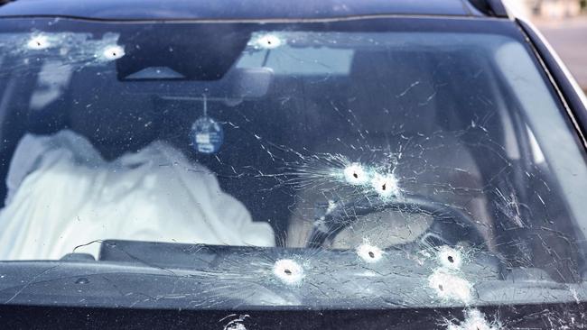 A body lies covered inside a bullet-riddled car in the southern city of Sderot on October 7. Picture: AFP