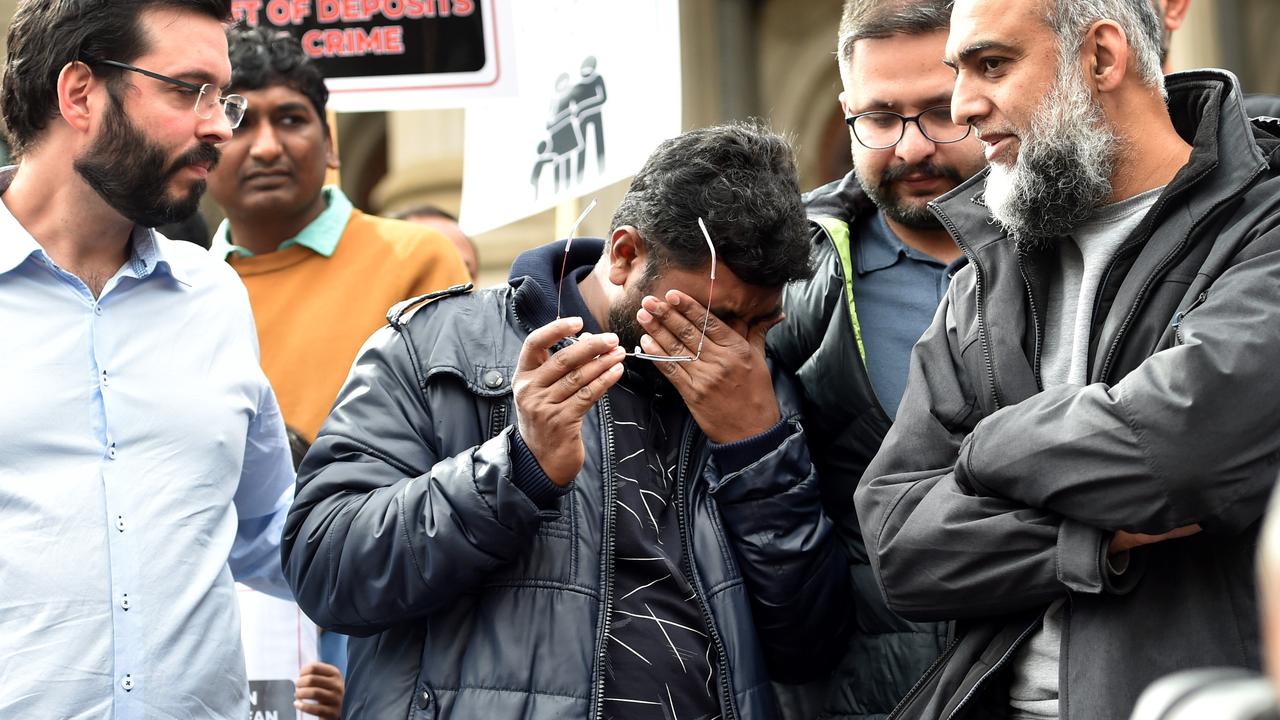 Amil Vemula weeps on the steps of parliament as victims of the Porter David collapse protest at Parliament House in Melbourne. Picture: Nicki Connolly