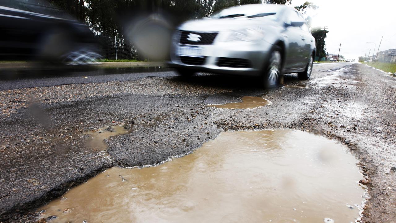 A large pothole filled with water on Fyfe Road, Kellyville Ridge in Sydney, one of Sydney's worst roads for potholes.