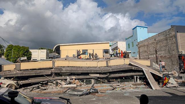 Rescue workers are seen at the site of a collapsed building after a powerful earthquake struck Port Vila, the capital city of Vanuatu. Picture: AFP