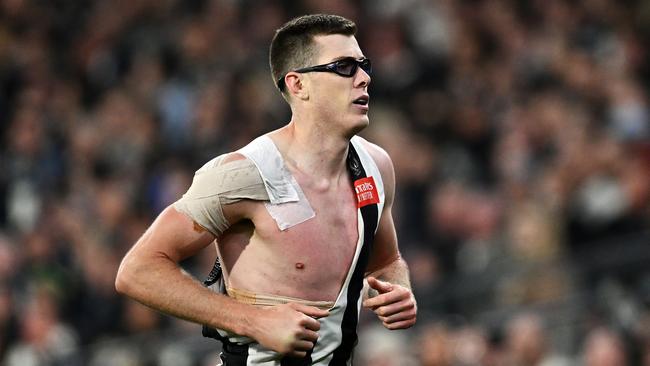 Mason Cox of the Magpies leaves the ground with a torn jumper. (Photo by Quinn Rooney/Getty Images)