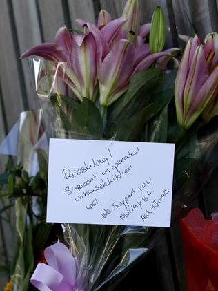 “Devastating, we support you”. Flowers line the footpath.