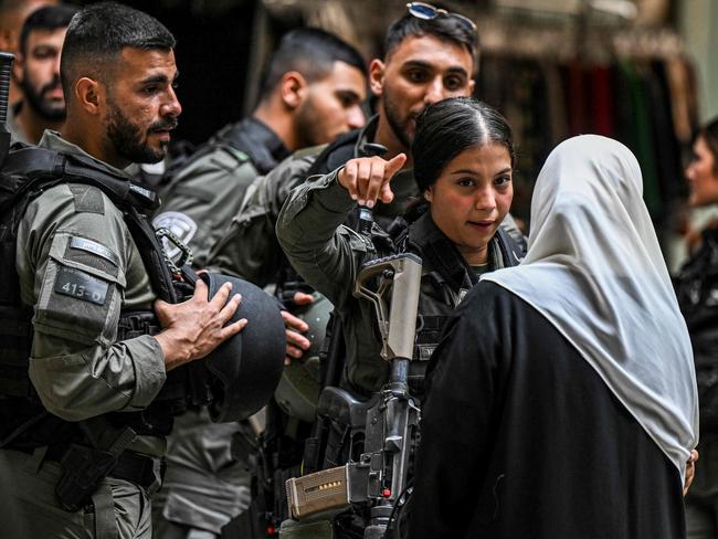 An Israeli border guard argues with a woman as Muslim worshippers are denied entry to the Aqsa mosque compound in the old city of Jerusalem. Picture: AFP