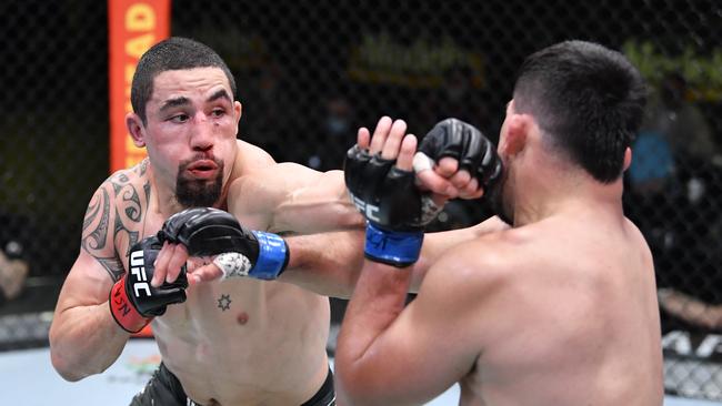 LAS VEGAS, NEVADA - APRIL 17: In this handout photo, (L-R) Robert Whittaker of Australia punches Kelvin Gastelum in a middleweight fight during the UFC Fight Night event at UFC APEX on April 17, 2021 in Las Vegas, Nevada. (Photo by Chris Unger/Zuffa LLC)