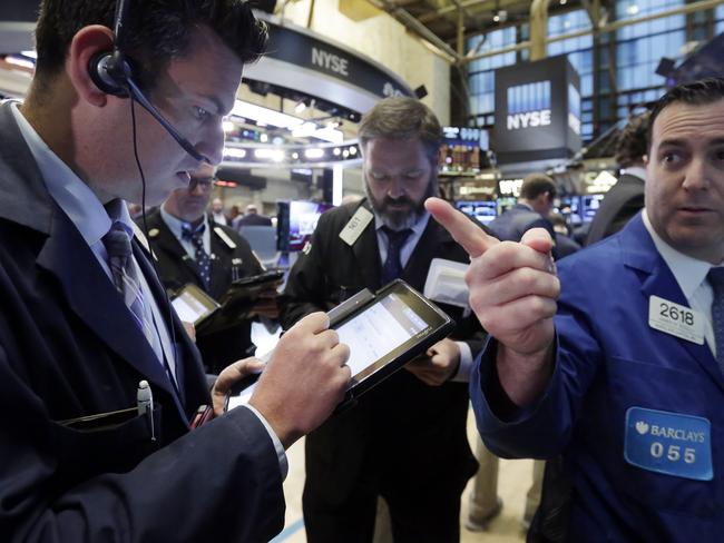 Specialist James Sciulli, right, works with traders on the floor of the New York Stock Exchange, Friday, Oct. 23, 2015. Technology shares are surging in early trading after several big-name companies reported big earnings gains. (AP Photo/Richard Drew)