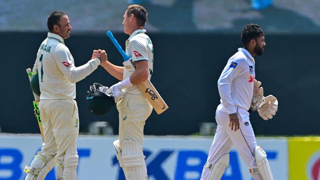 Australia's Usman Khawaja (left) and Marnus Labuschagne celebrate after wrapping up the victory. (Photo by Ishara S. KODIKARA / AFP)