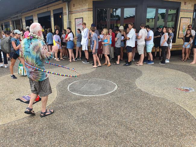 A busker provided entertainment for those waiting in the long queue for Splendour in the Grass locals' tickets at the Great Northern Hotel in Byron Bay on Sunday.