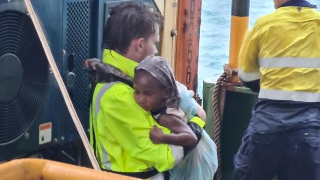 A one-year-old baby is comforted after the ordeal by A Sea Swift worker. Picture: Sea Swift