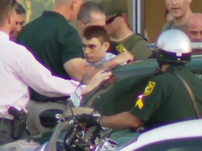 Nikolas Cruz, the suspect in a shooting at Marjory Stoneman Douglas High School in Parkland, is escorted out of a hospital and into a police car. Picture: WPLG FLorida